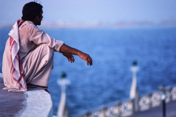 Man Squatting, Sea in Background, Abu Dhabi