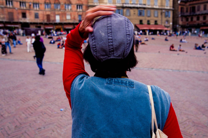 Woman, Hand on Cap in Square in Sienna, Cortona
