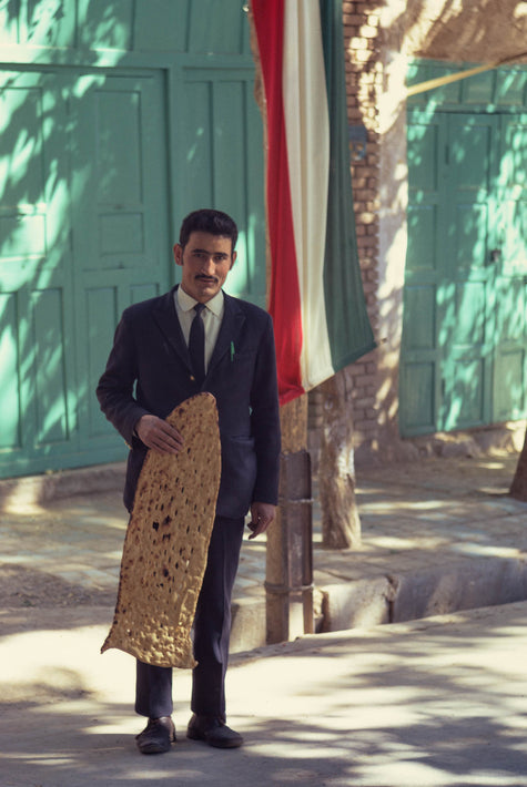 Man Holding Bread near Iranian Flag, Iran