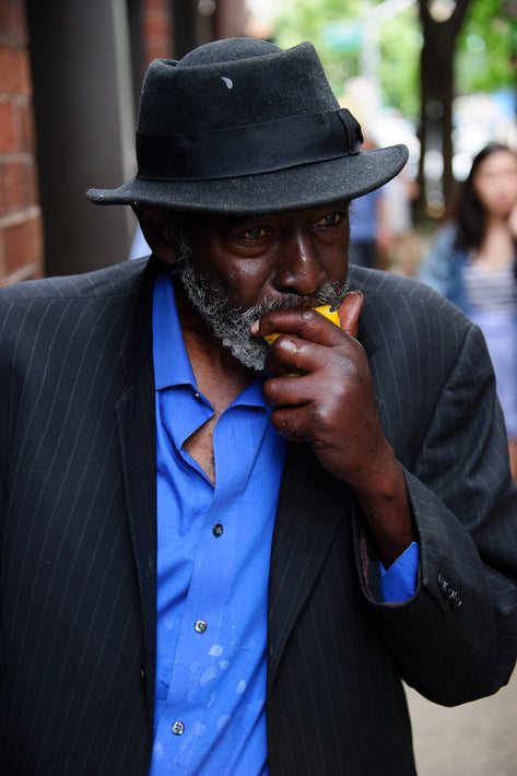 Man in Blue Shirt, Orange to Mouth, NYC