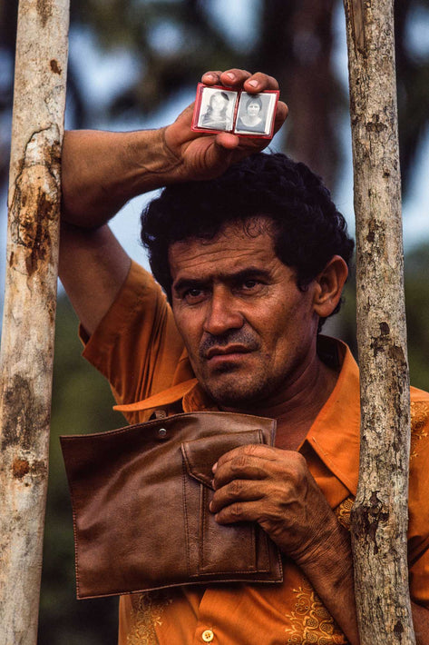 Man Holding Up Photos for Faith Healer, Bahia