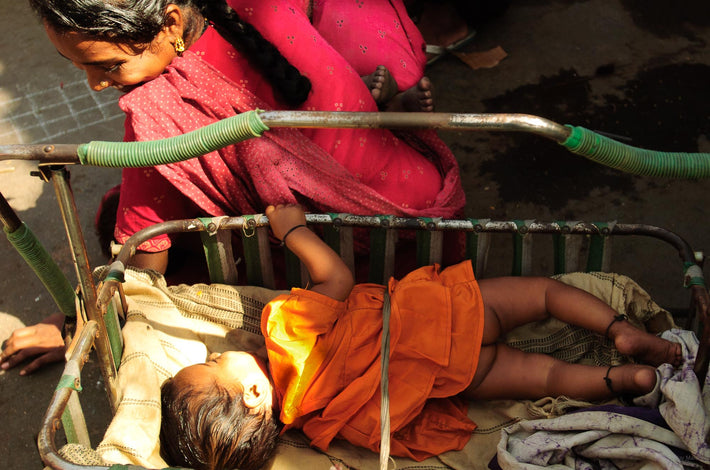 Woman with Baby in Lap Looking at Child in Crib, Mumbai