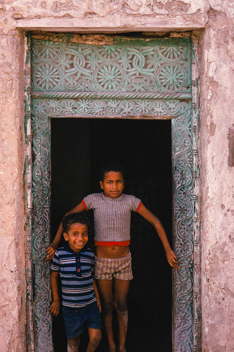 Two Kids in Door Frame, Green Background, Somalia