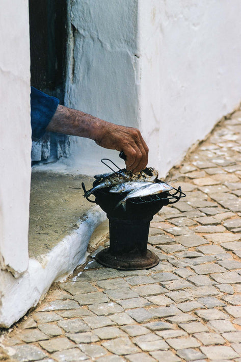 Hand Reaching to Tend Fish, Portugal