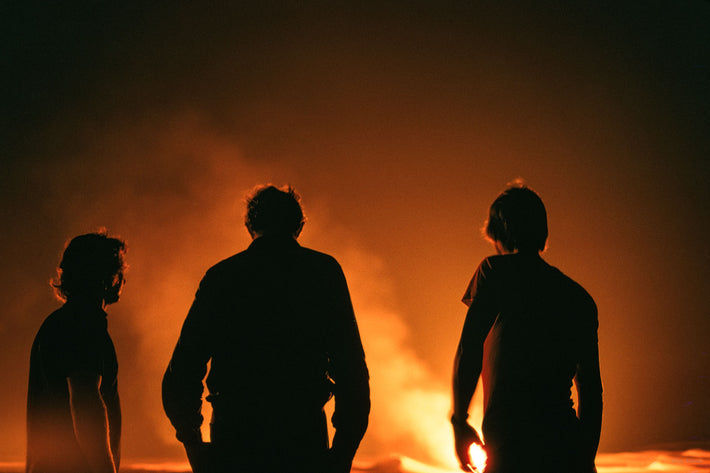 Three Men Silhouetted Against Flames