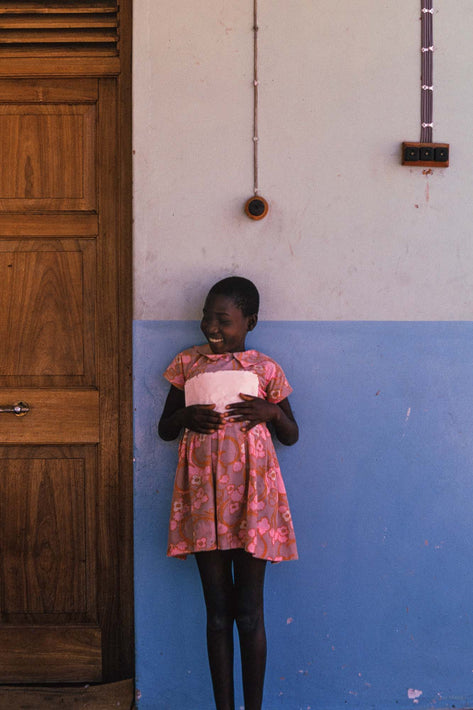 Girl Holding Paper Smiling, Kenya