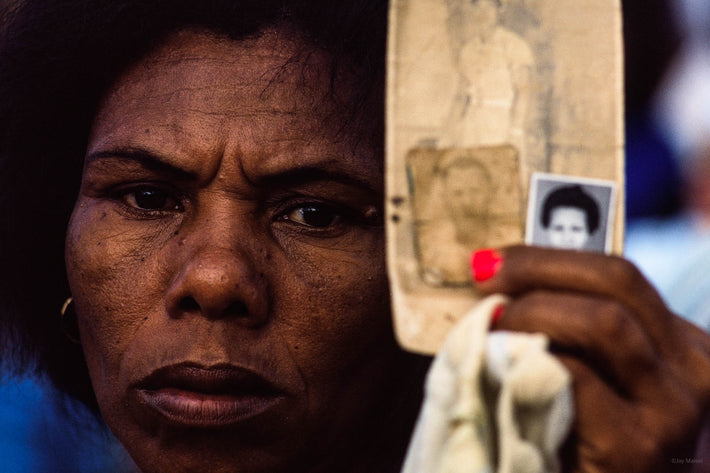 Woman Close-up Holding Up Photos for Faith Healer, Bahia